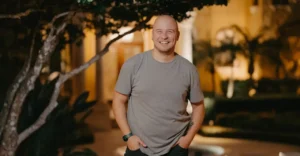 Sahid Pabon smiles at the camera in an evening shot by some trees